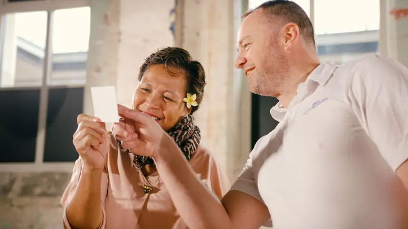 Women and Man looking at a polaroid together 